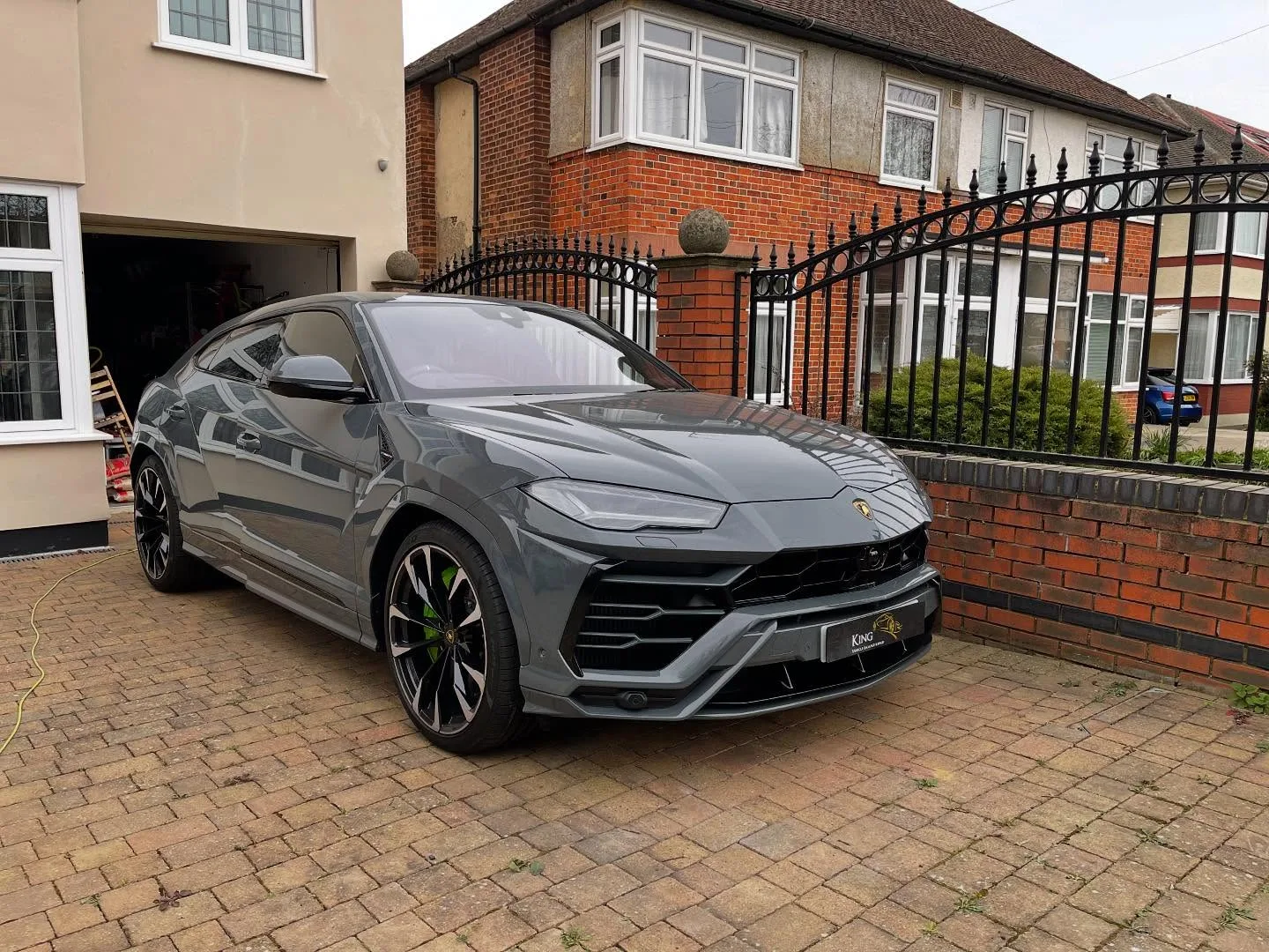 Grey Lamborghini Urus on a customer's driveway with a King plate