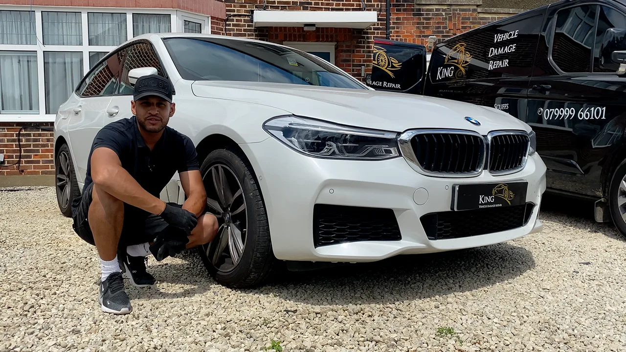 King technician beside a repaired white BMW and the branded King vans